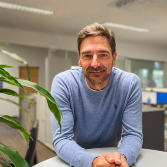 Marcus Idinger, Head of Product Center, Embedded Computers, über Stehtisch gelehnt neben einer Pflanze