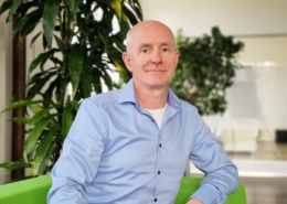 Patrick von Unold, technischer Leiter, auf einem grünen Stuhl vor einer Pflanze sitzend